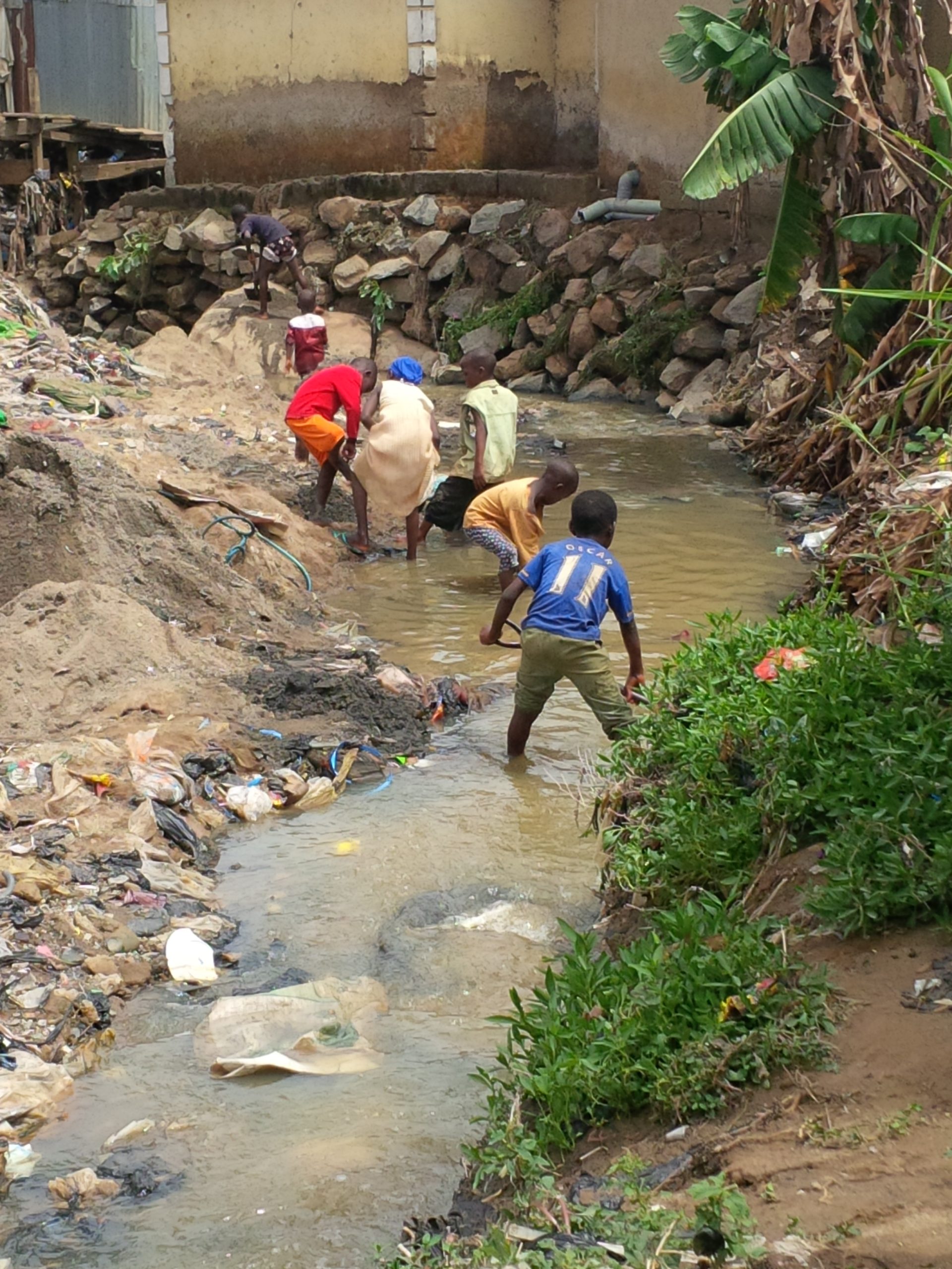 Children near wastewater drainage in Mpape, Nigeria, photographed during a 2014 cholera investigation