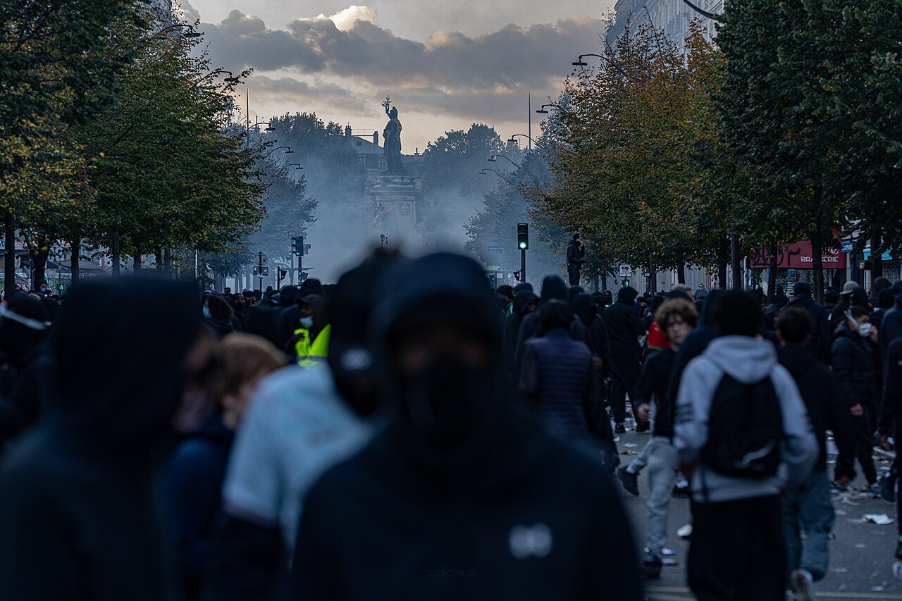 A crowd faces Place de la Republique in Paris through tear gas during protests on October 17, 2026