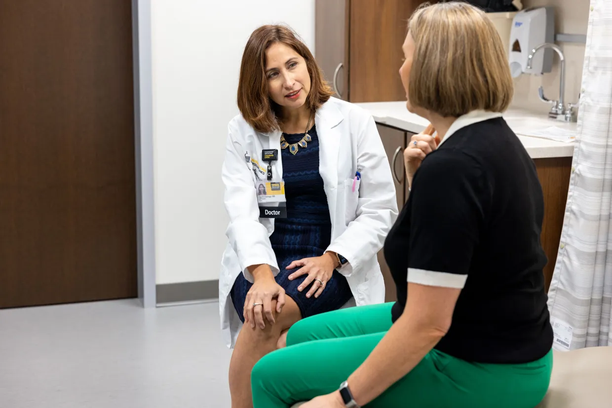 A physician speaks with a patient during a clinical consultation, not a photograph of the White House event