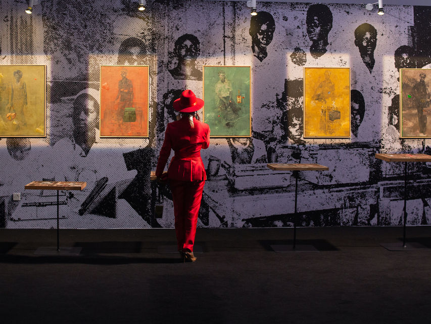 A visitor studies works at ART X Lagos 2025, an archival view ahead of the 2026 edition