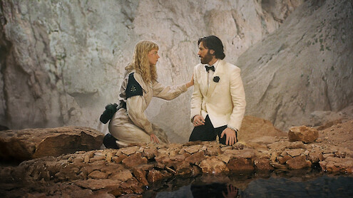 Anya Taylor-Joy and a man in a white tuxedo during a tense scene in Sacrifice