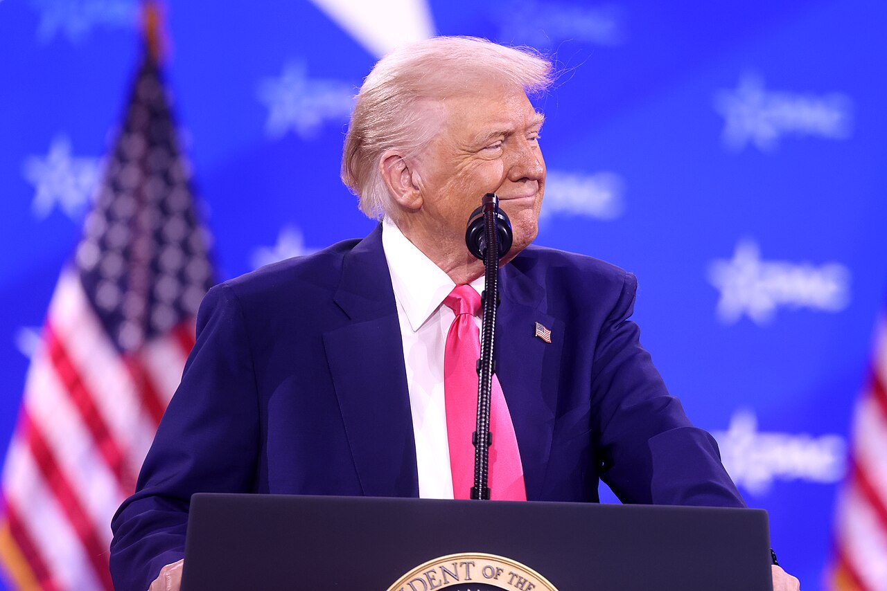 Donald Trump at CPAC 2025 — Gage Skidmore Donald Trump speaks at the 2025 Conservative Political Action Conference, with an American flag behind him.