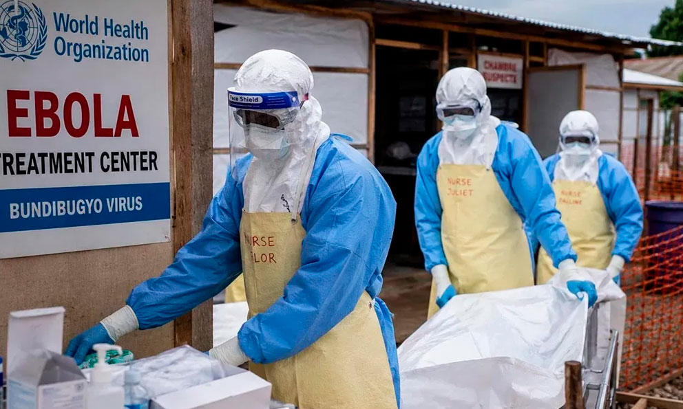 Ebola response workers wearing personal protective equipment outside a treatment facility, not the Abuja patient’s hospital
