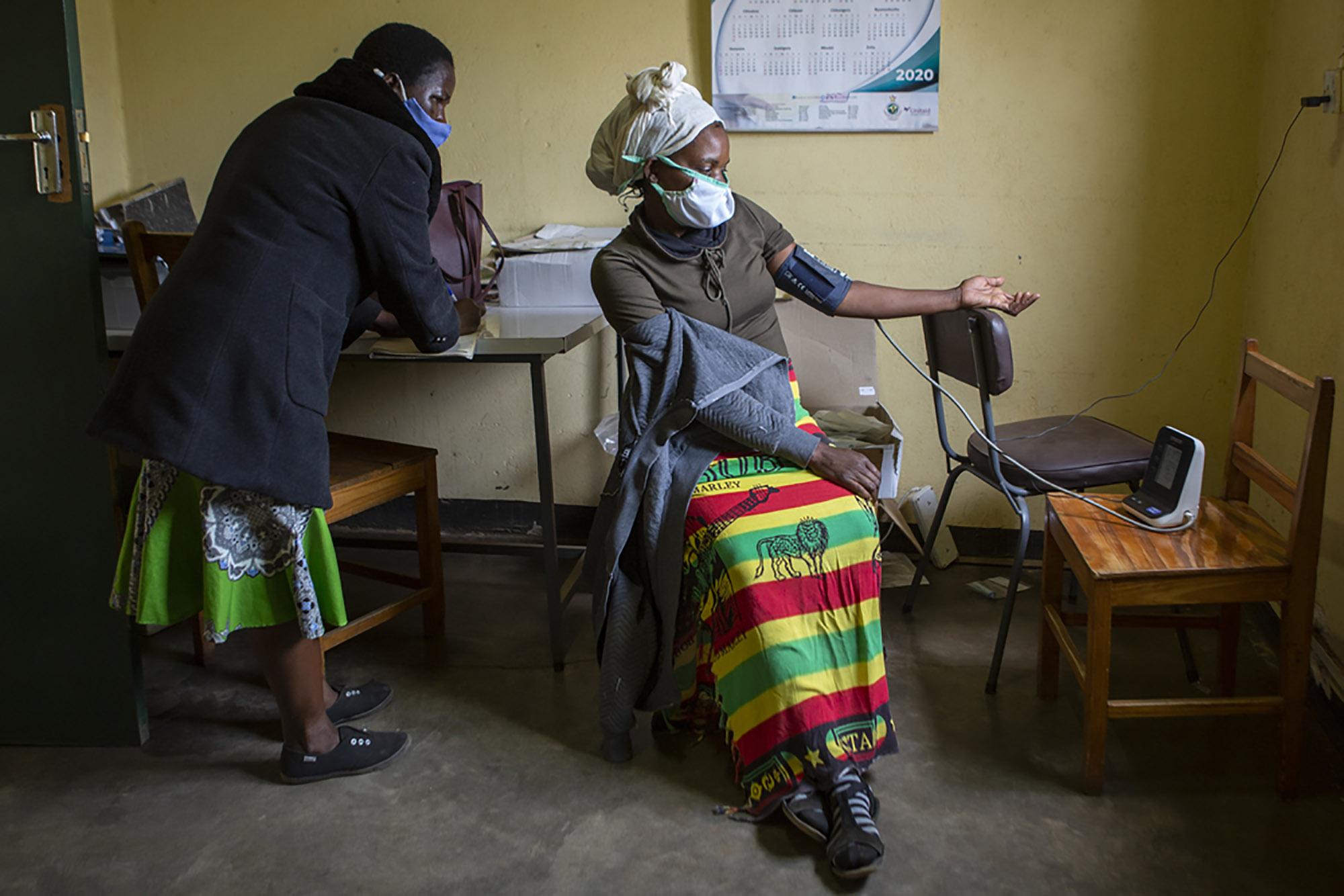 A nurse measures a patient’s blood pressure during chronic disease care in rural Zimbabwe