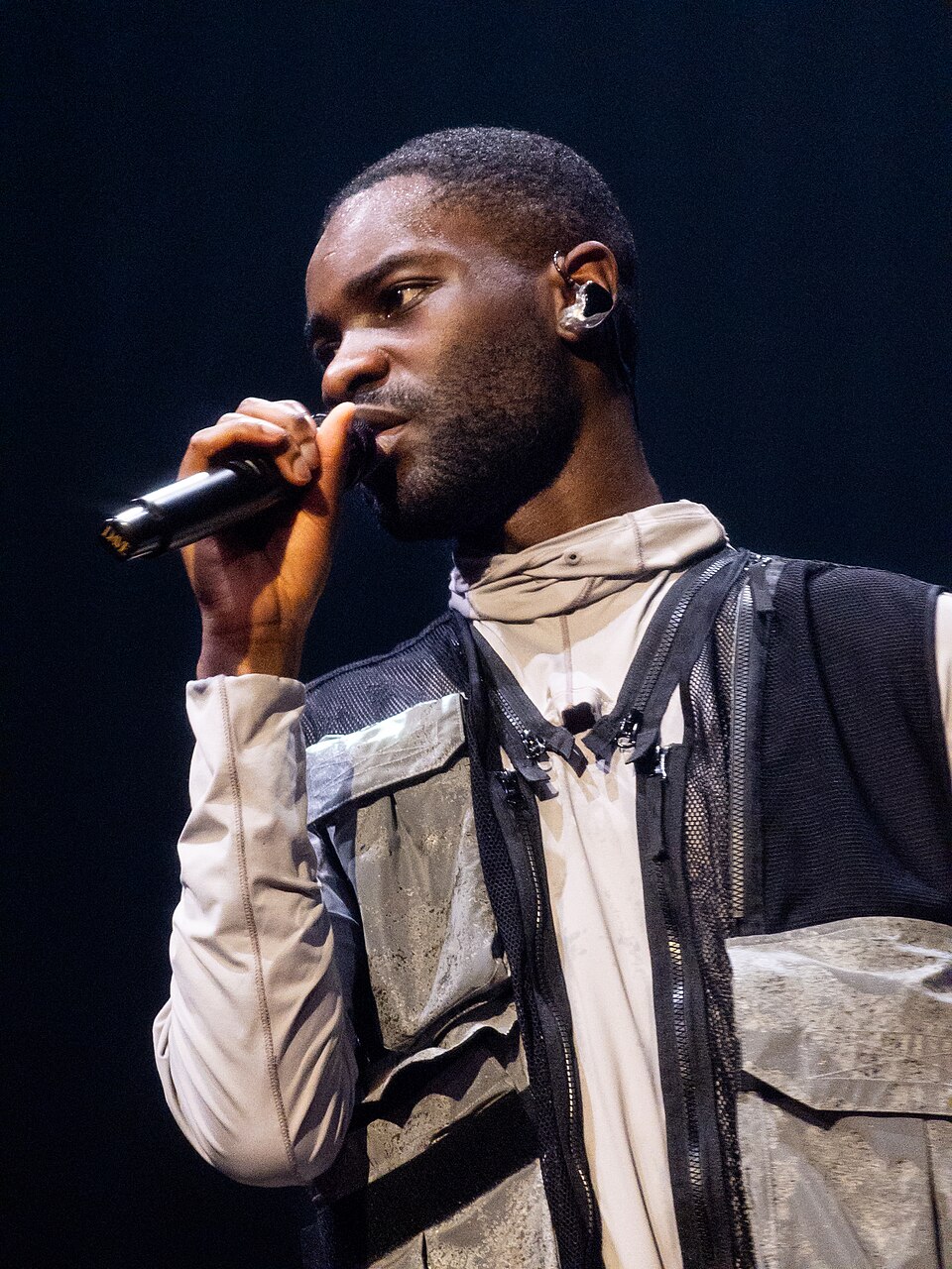 Dave performing live in Brussels, 2026 British rapper Dave performing live on stage with a microphone in Brussels on February 6, 2026