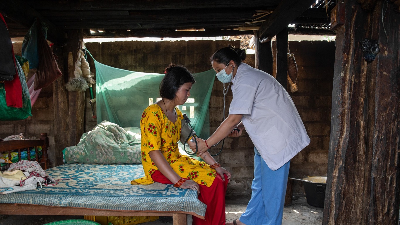A health worker checks a woman’s blood pressure during a rural clinic visit