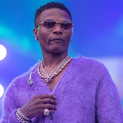 Wizkid performing under purple stage lights