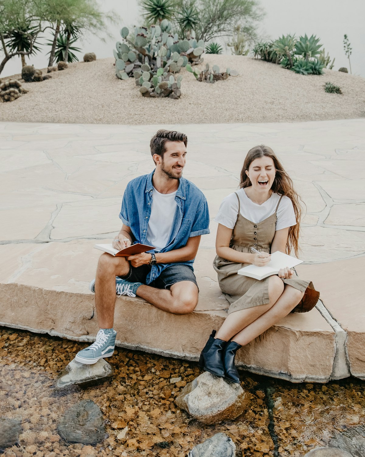 A couple sharing a relaxed conversation over notebooks at a table