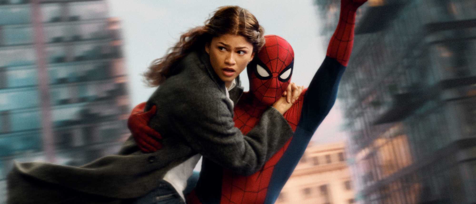 Zendaya as MJ and Tom Holland as Spider-Man swing above the city in a Brand New Day film still